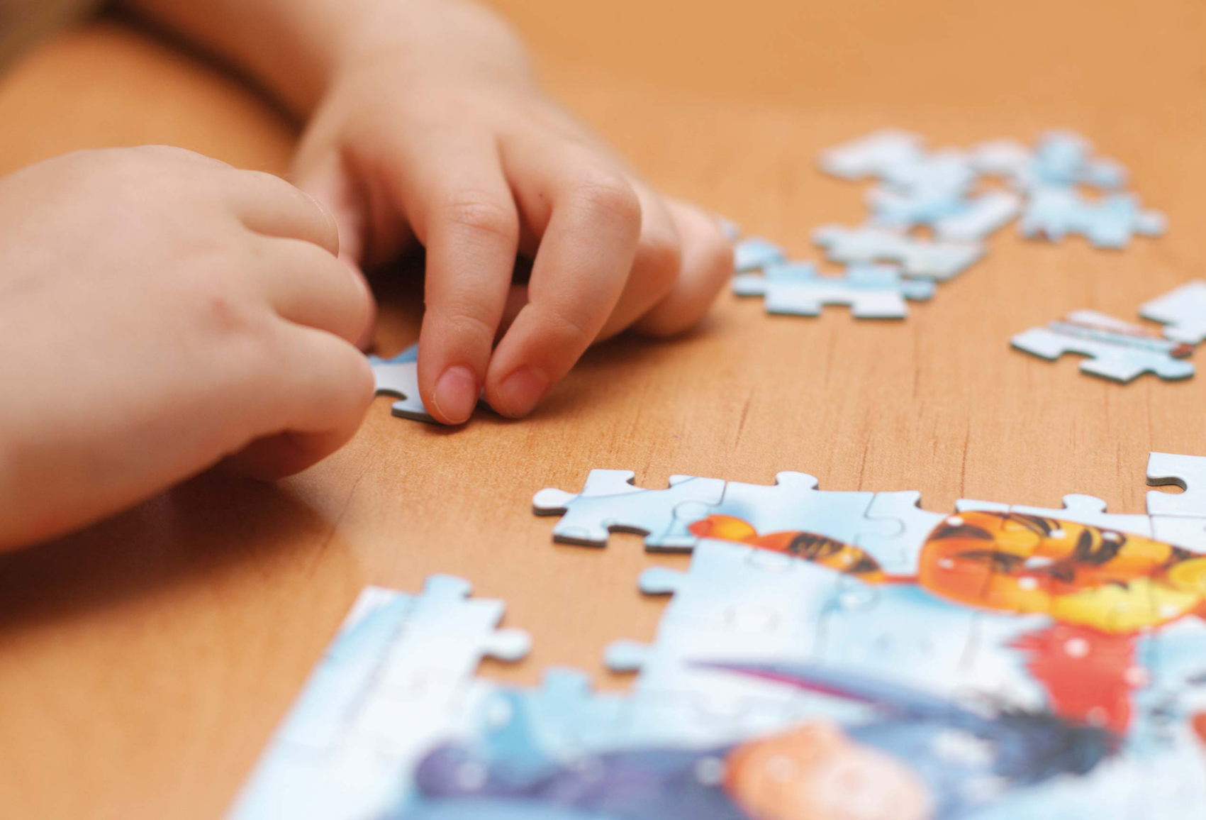 puzzle in kid hands - extremely shallow dof - focus on one finger